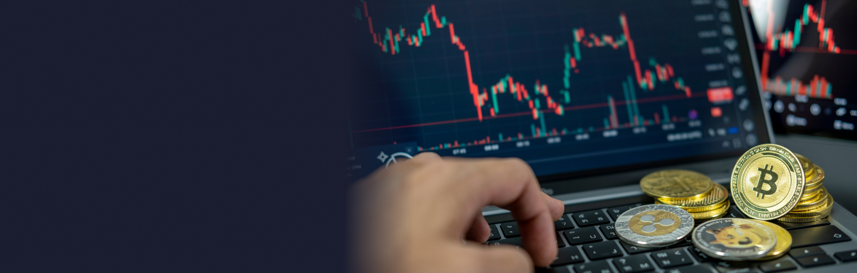 Person using a laptop with crypto coins, displaying a candlestick crypto price chart